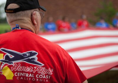 Back of t-shirt of a veteran olding the American Flag