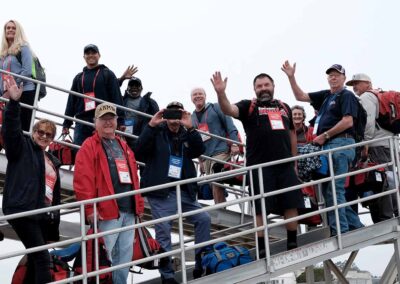 "A group of veterans and their guardians walk towards the plane, ready to begin their emotional tour of honor, filled with anticipation and respect for their shared journey."