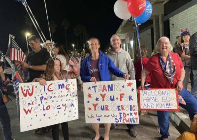 People holding "Welcome Home" signs at the airport as veterans return from their Honor Flight trip.